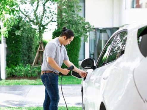 man charging electric car