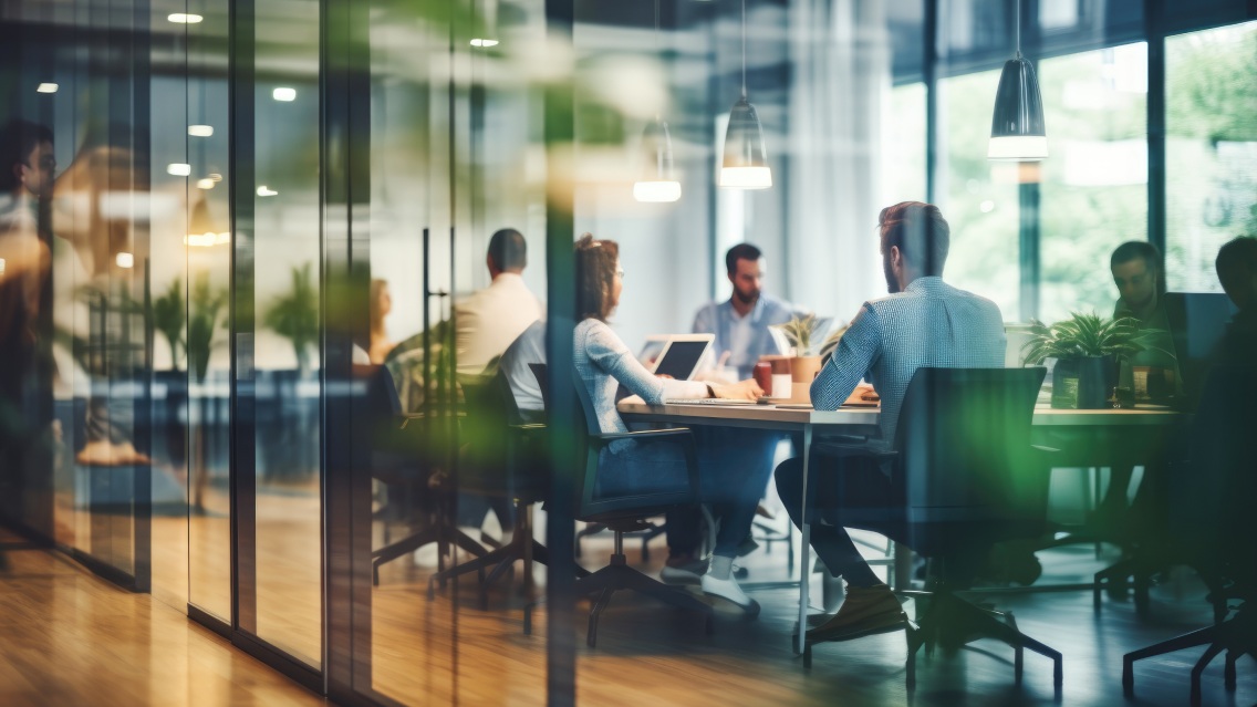 Group of professionals having a meeting at a conference table in a corporate setting.