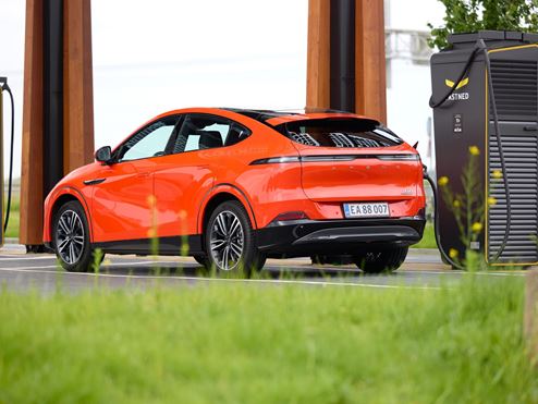 Orange EV on charge at a station