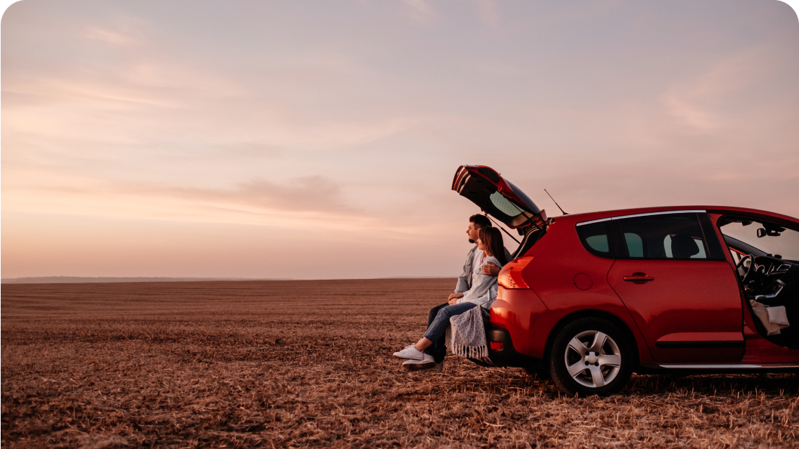 Family sitting in a car boot in an open landscape
