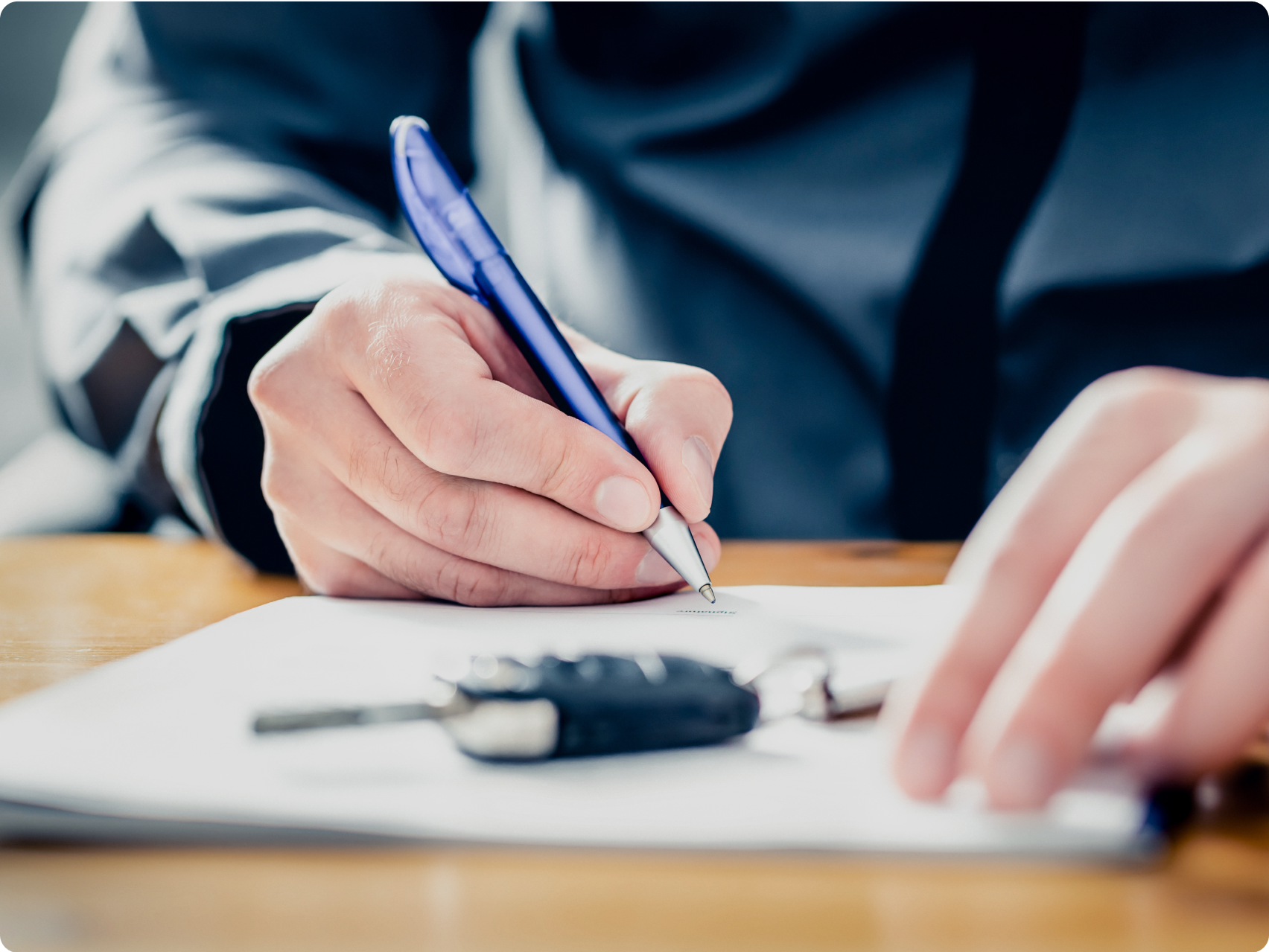 A person signing a contract for a car