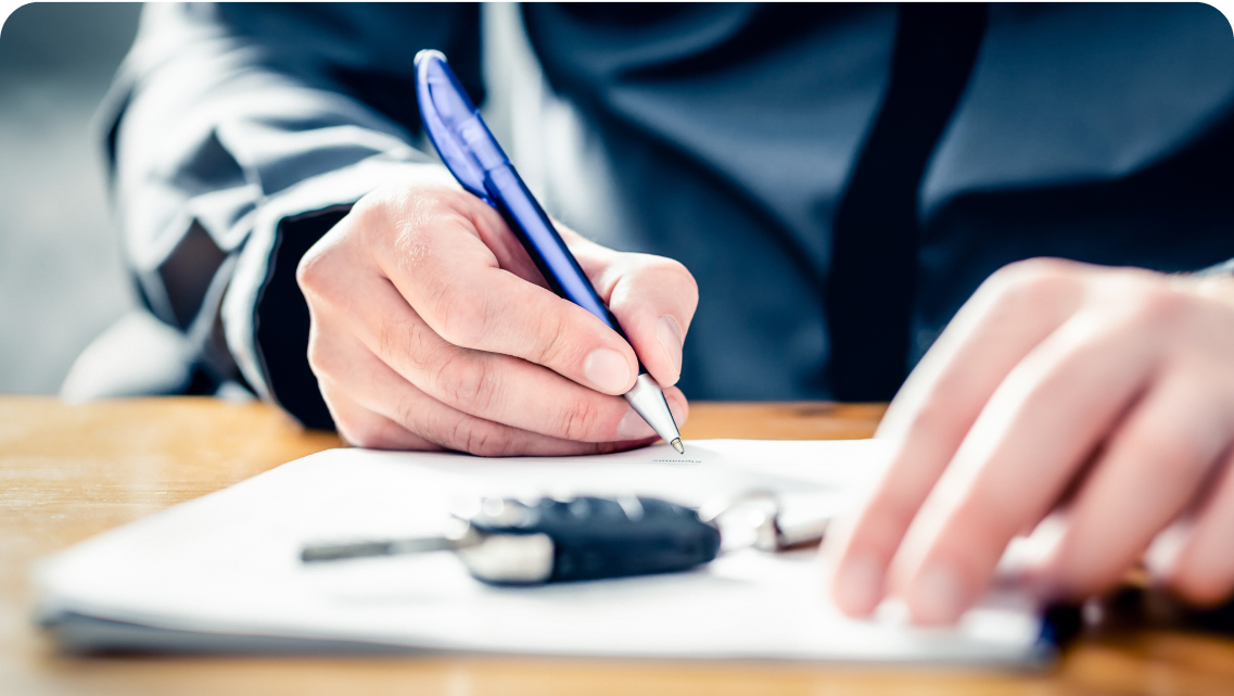 A person signing a contract for a car
