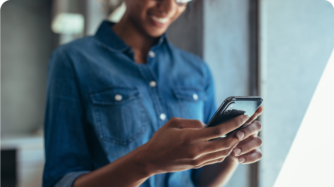 A woman smiling at her phone