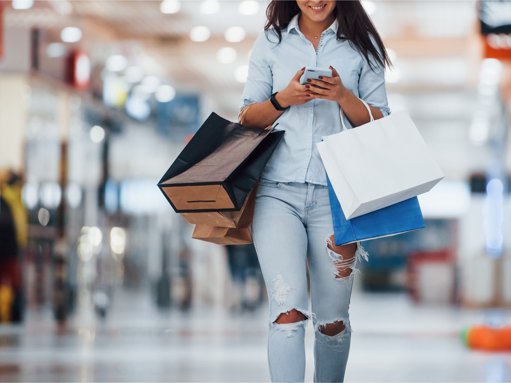 A women walking through a shopping center with shopping bags
