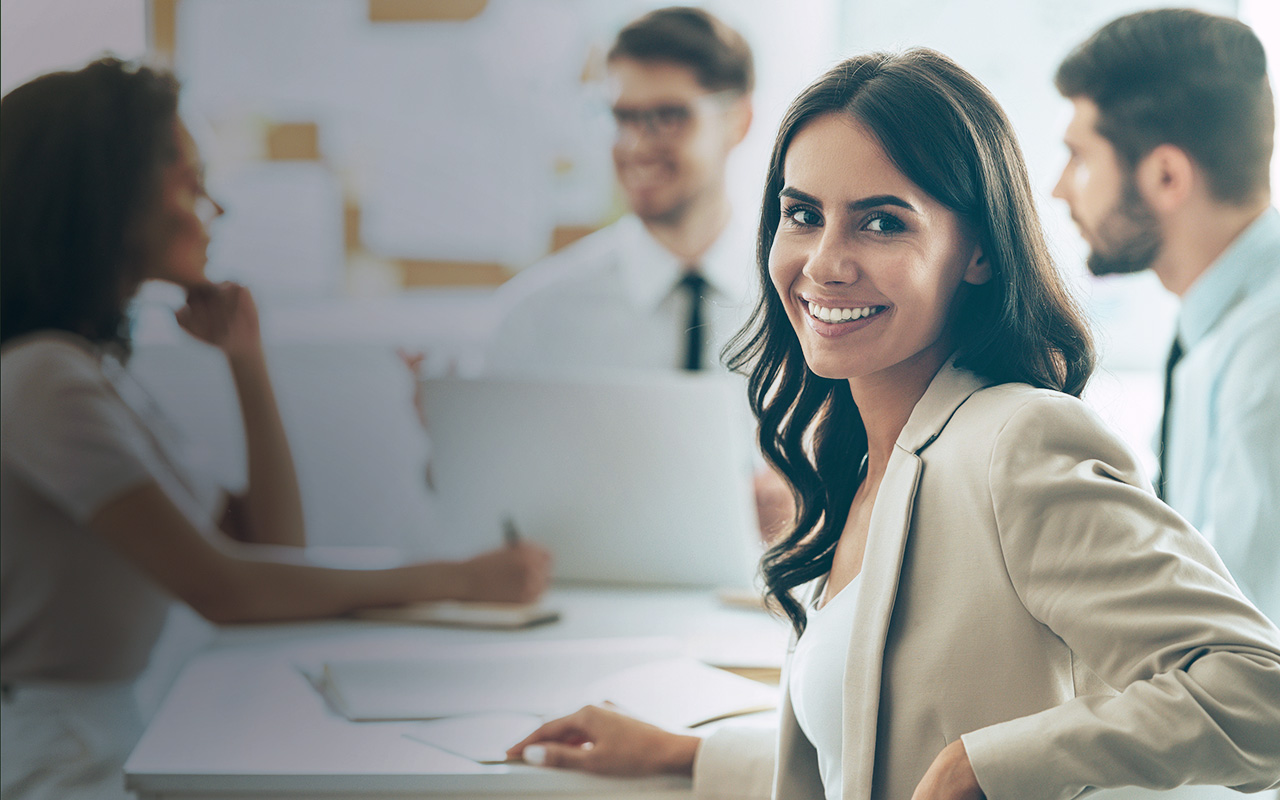 office meeting woman in foreground smiling